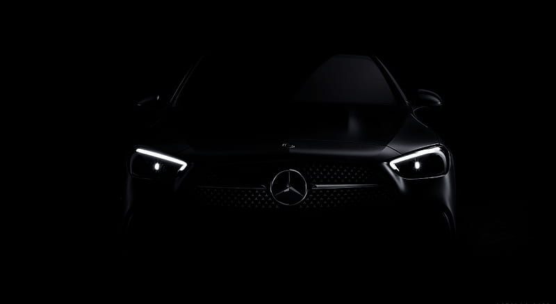 Chauffeur opening the door of a black luxury sedan at dusk